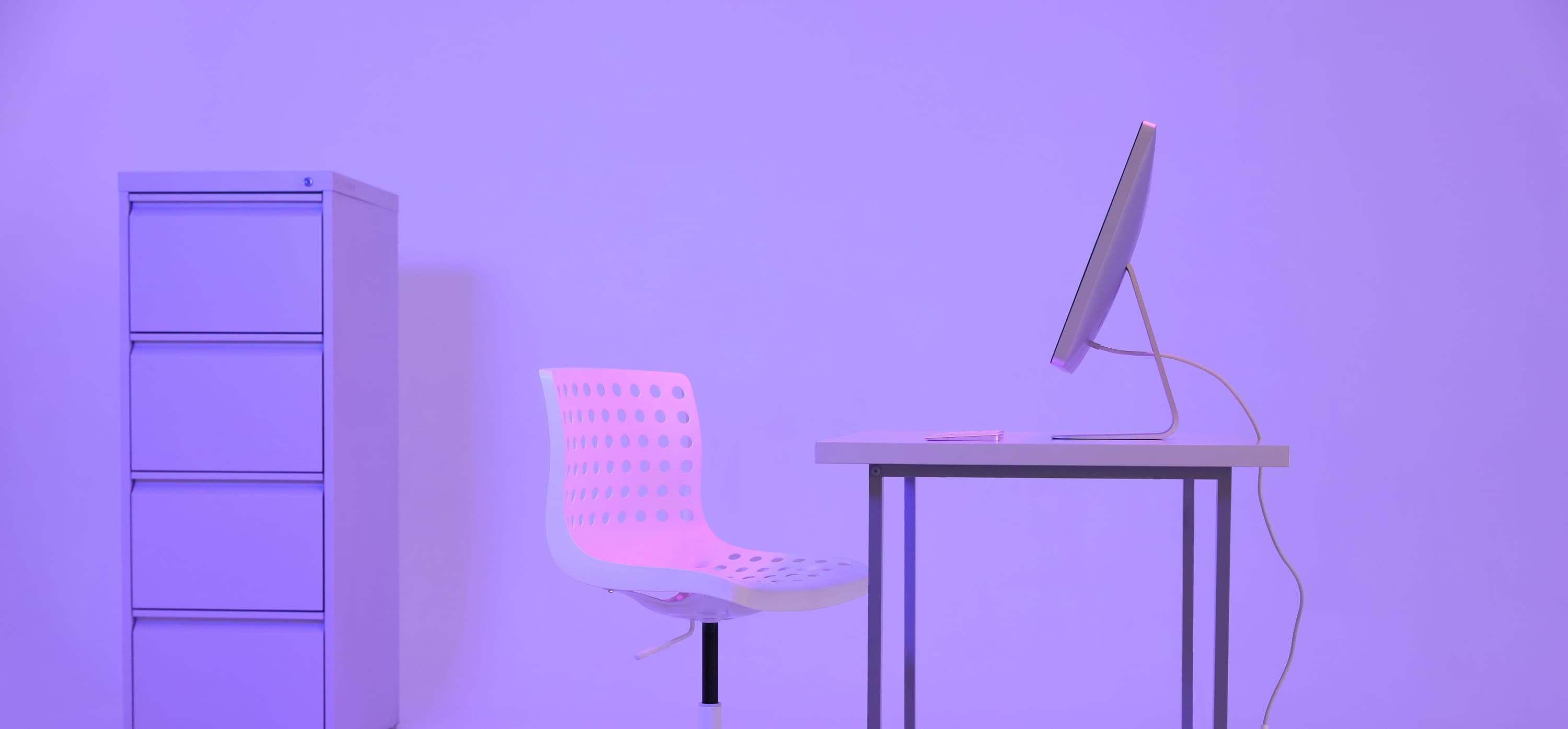 Computer and chair in neon lit room