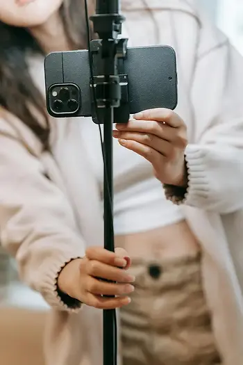 Person setting up a smartphone on a tripod to shoot trade-show content