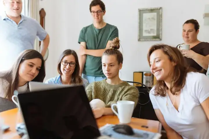 Team debriefing around a laptop after a trade show