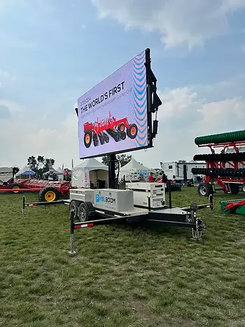 Large outdoor display with red farming equipment at a trade show
