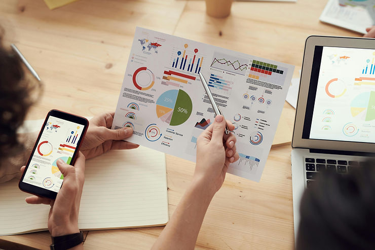 Marketing charts on paper, mobile and laptop
