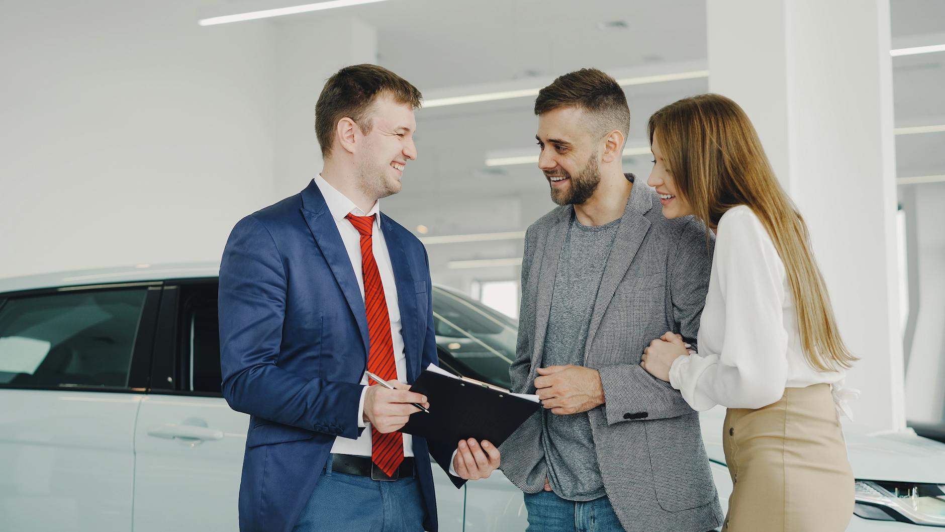 Customers consulting with a car salesperson in a dealership