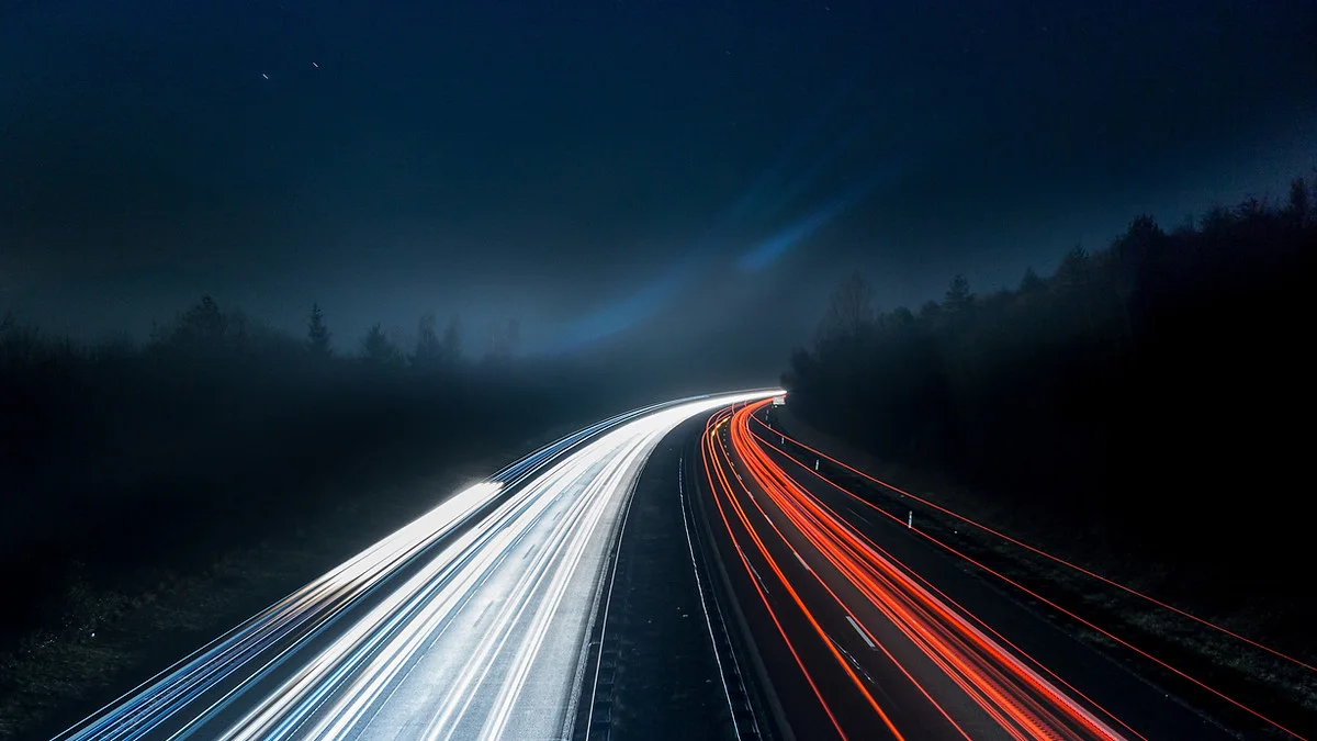 Highway Neon Lit Up At Night With Rapid Traffic