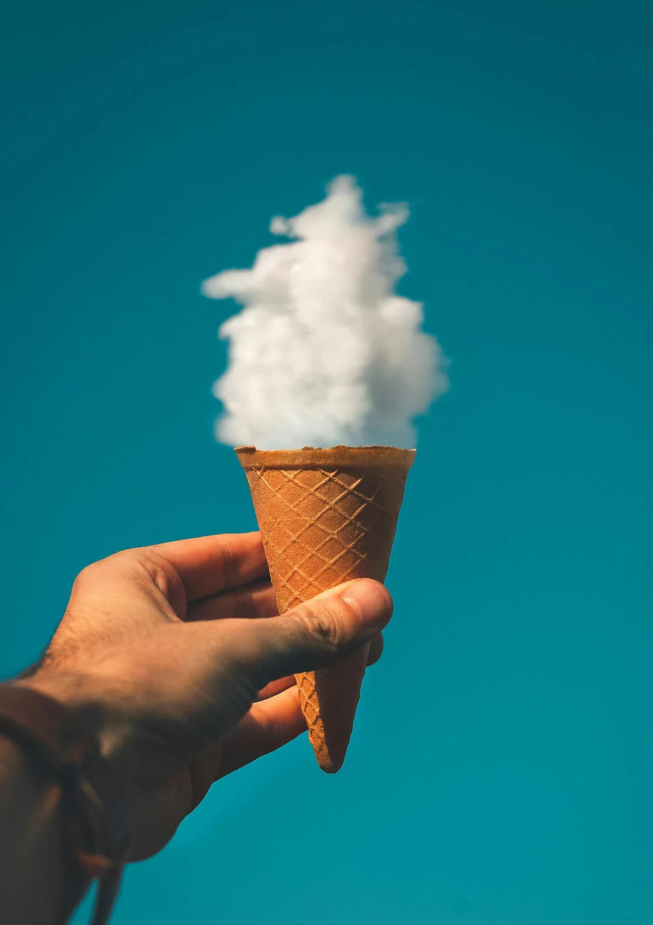Ice cream cone held up to cloud