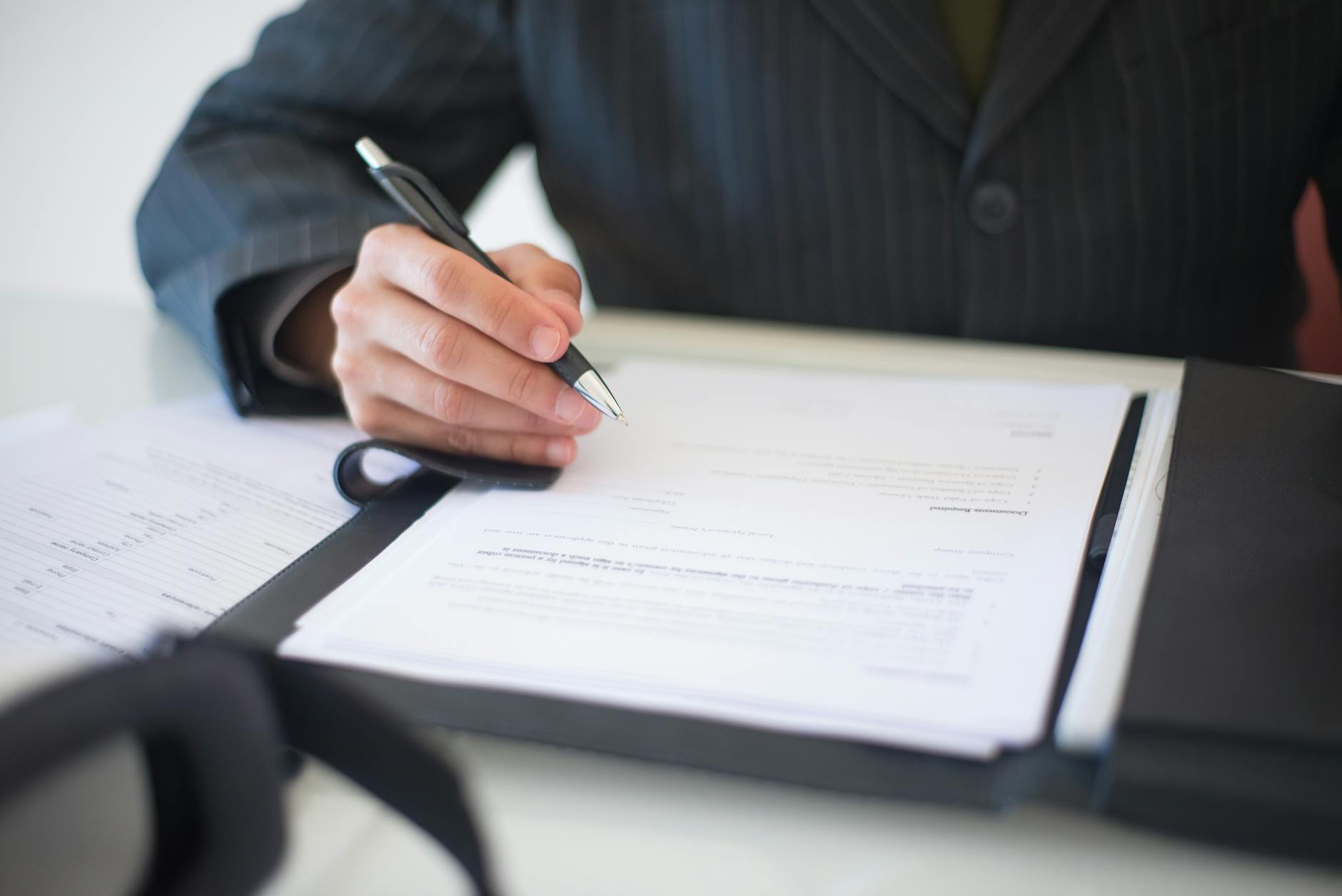 Person signing business proposal documents