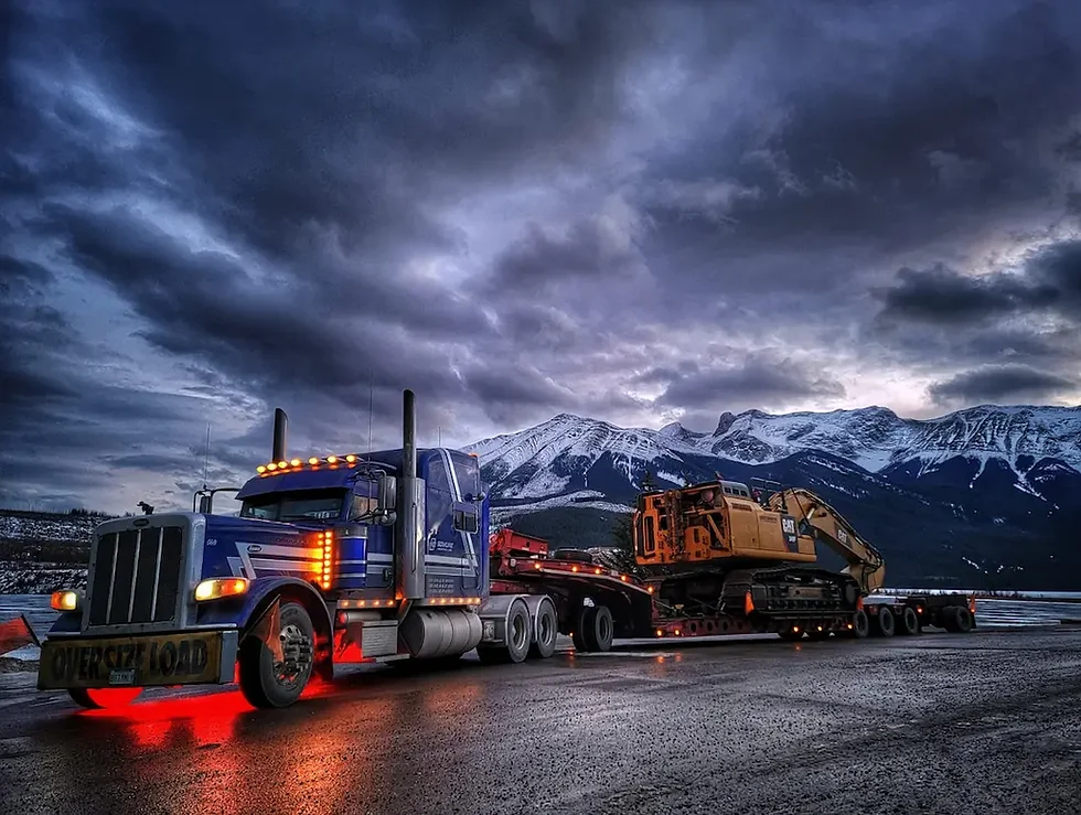 Bowline Logistics heavy-haul truck hauling equipment near the mountains